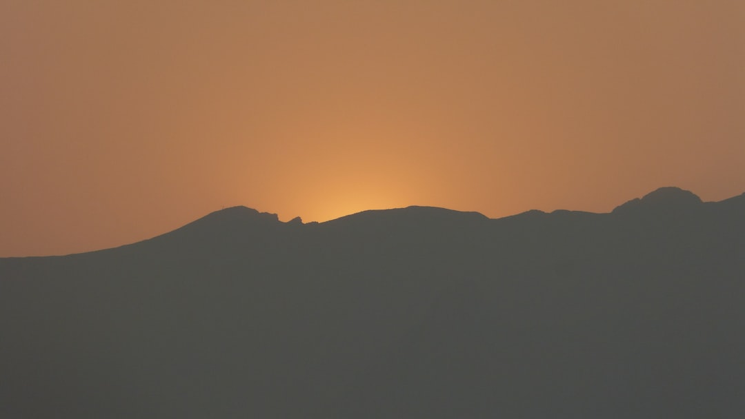 silhouette photo of mountain, Golden sunset cause by wildfire smoke in the distance