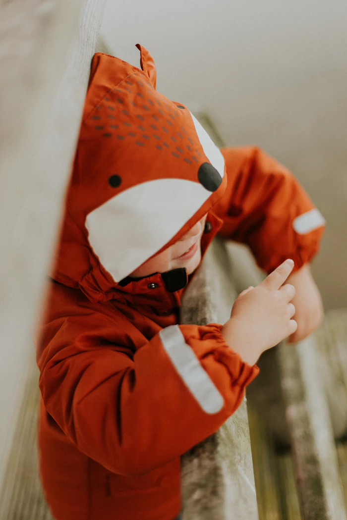 Toddler wearing an orange fox-eared jacket