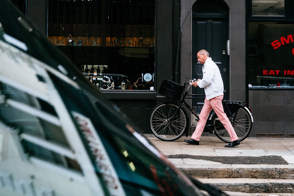 homme marchant à côté d’un vélo