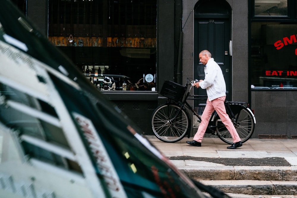 man walking beside bicycle
