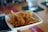 Close-up of crispy banana chips in a rustic bowl on a wooden table.