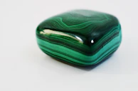 A polished emerald reflecting its deep green color with subtle inclusions.