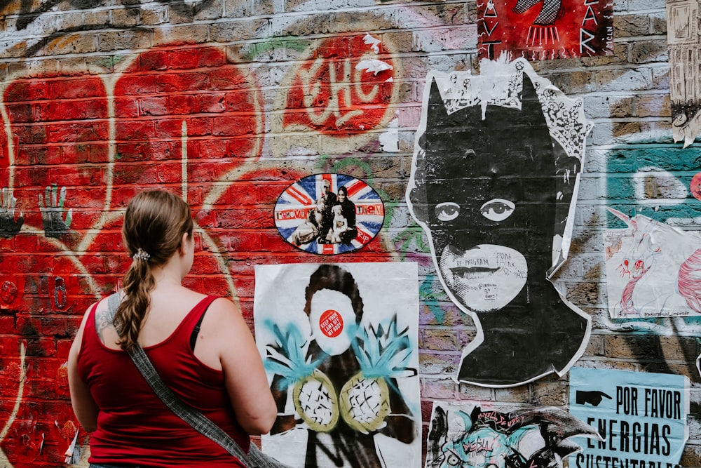 Frau schaut sich Batman-Graffiti-Wandkunst an