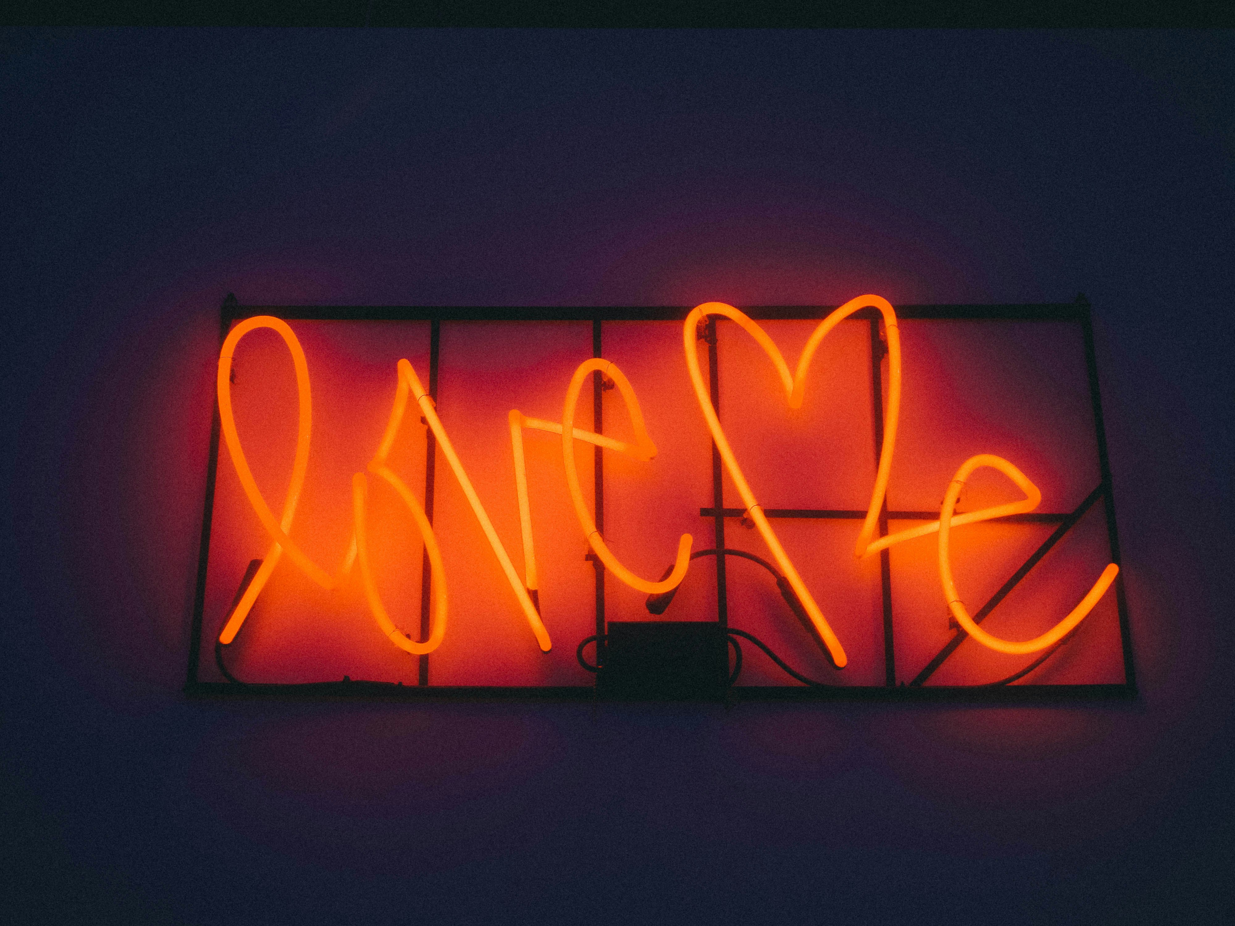 red and white love me neon signage turned on