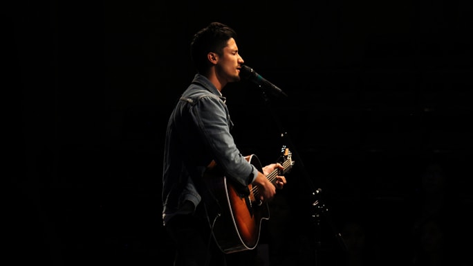man playing guitar while singing