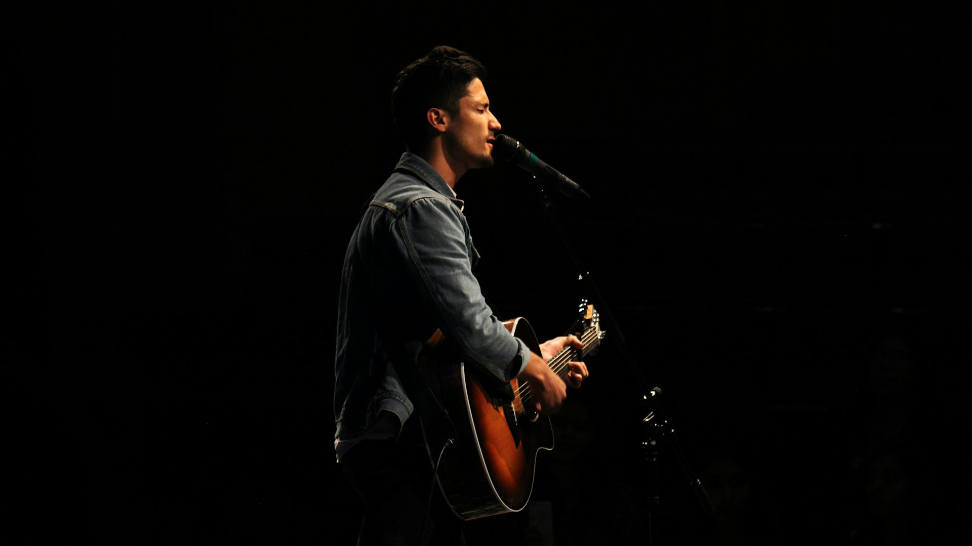 man playing guitar while singing