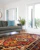 teal 2-seat couch and red area rug