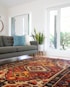 teal 2-seat couch and red area rug