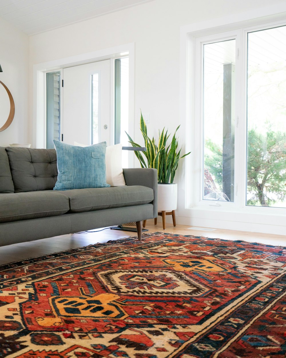 teal 2-seat couch and red area rug