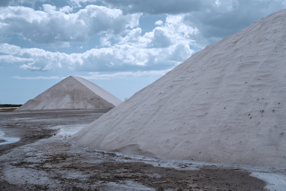 beige hills under white cloudy sky at daytime