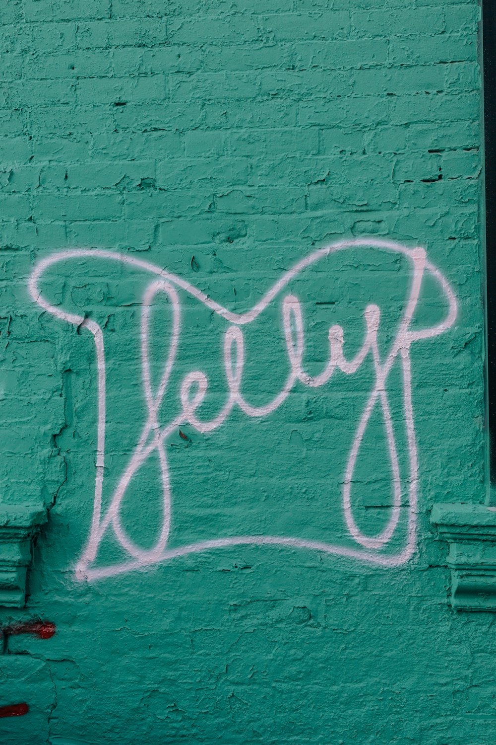 purple brick wall with white and black graffiti