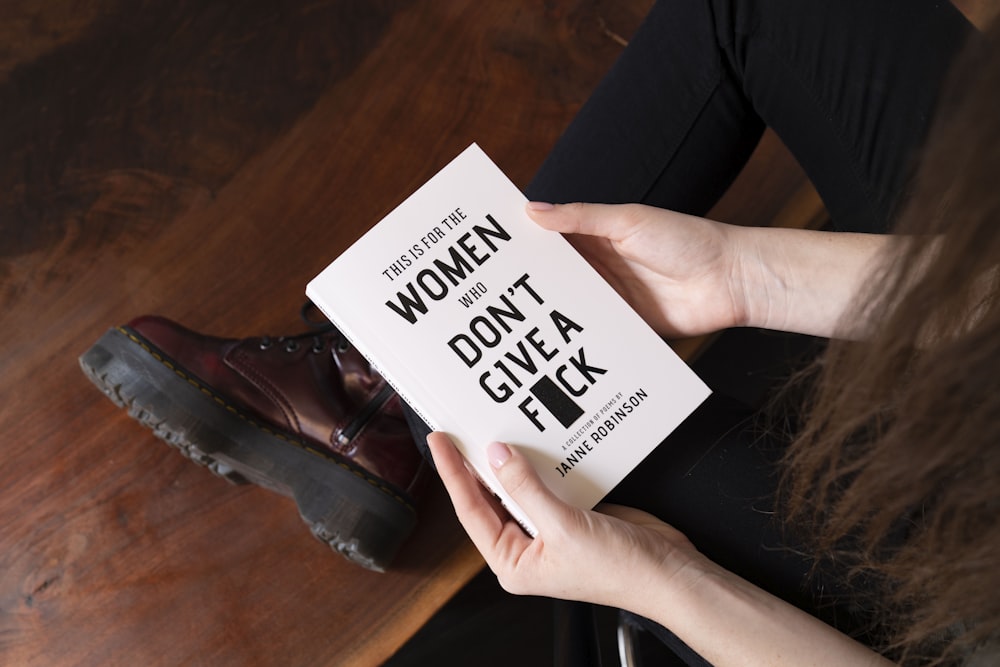 woman holding This is for the women who don't give a fuck book