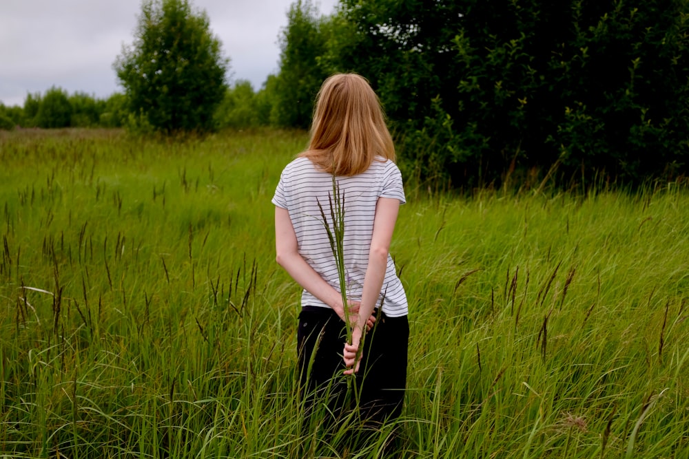 femme debout sur le champ d’herbe