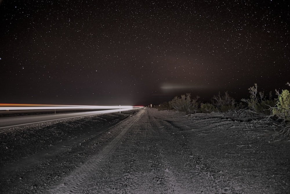 a night time shot of a road with a car passing by