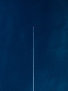aircraft with line of air on blue sky