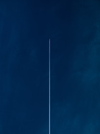 aircraft with line of air on blue sky
