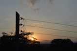 Photo of Energisa technicians repairing power lines at sunset