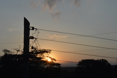 Photo of Energisa technicians repairing power lines at sunset