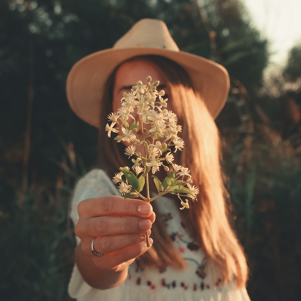 woman handing white flowers to the photographer