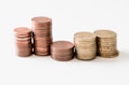 stacked round gold-colored coins on white surface