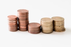 stacked round gold-colored coins on white surface