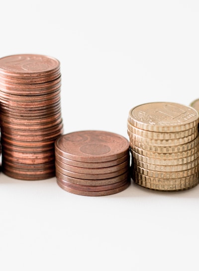 stacked round gold-colored coins on white surface