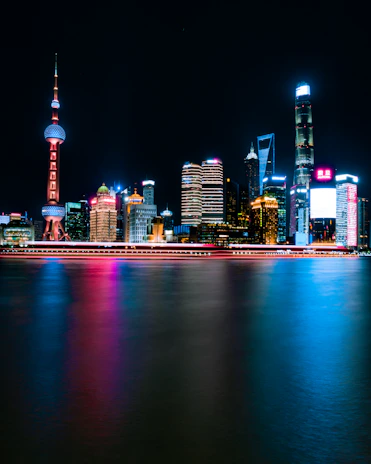 Futuristic city skyline at night with glowing blue and neon lights reflecting technology and connectivity.