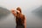 woman holding hair facing body of water during daytime