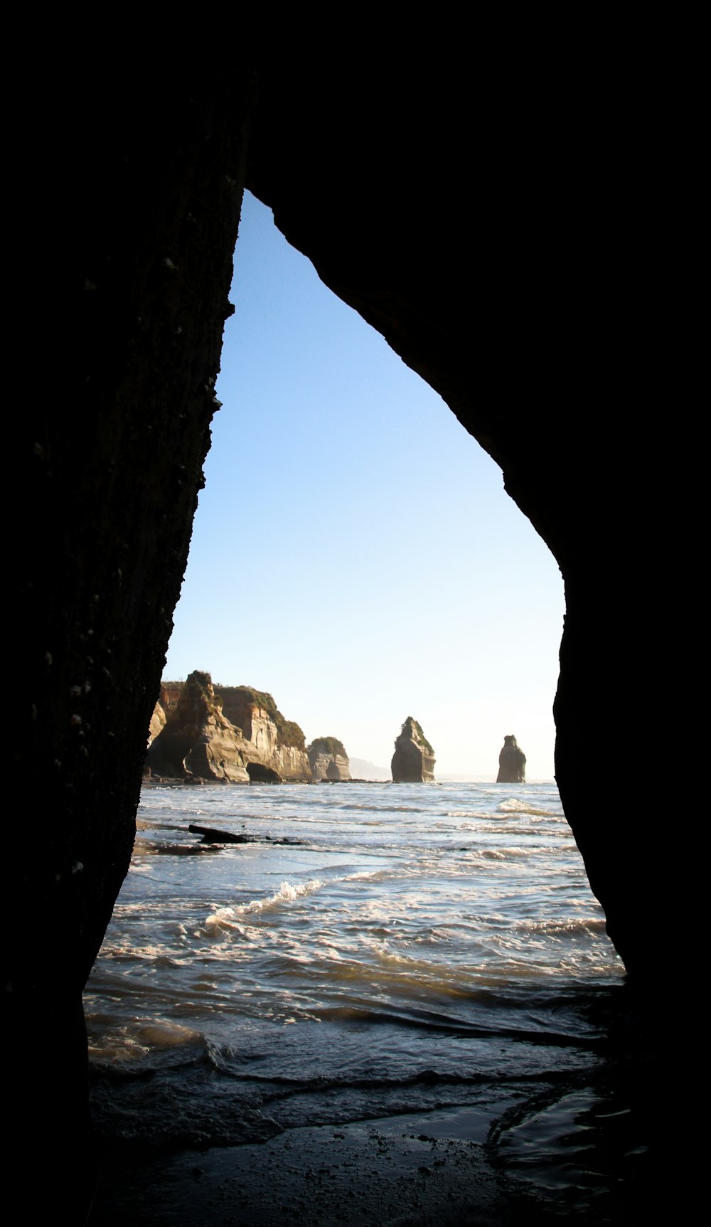 cave on seashore during daytime