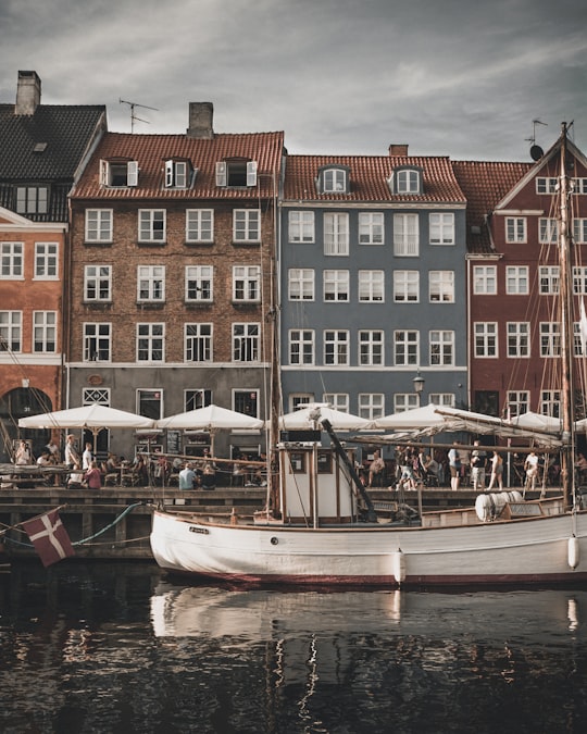 white boat canal houses during daytime in Nyhavn Denmark