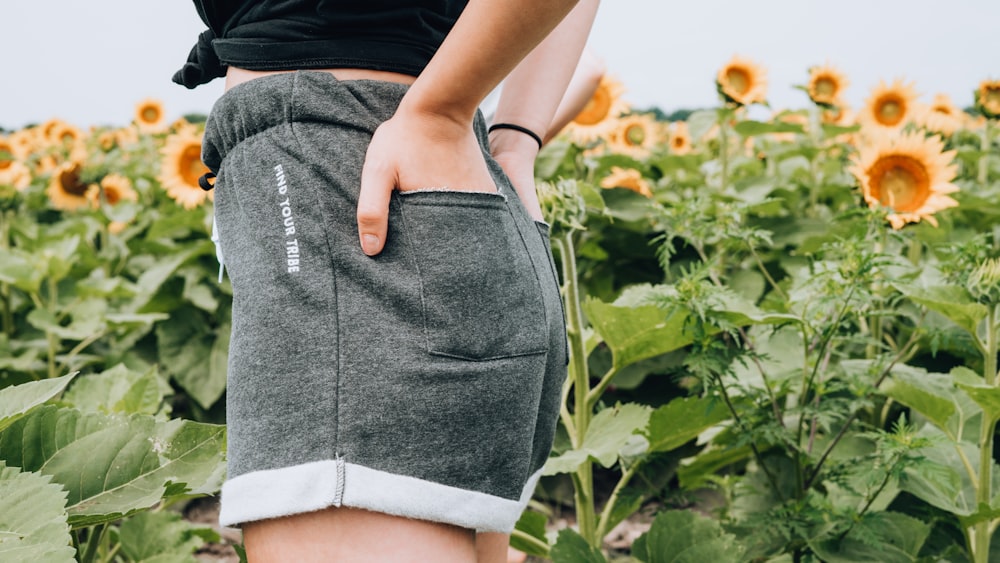 femme debout sur la prairie de tournesol tenant la poche