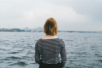 woman facing body of water