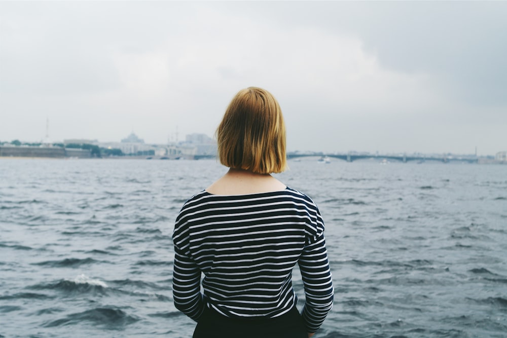 woman facing body of water