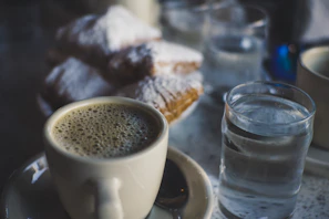 A close-up of a traditional Turkish coffee cup with rich foam and a small glass of water