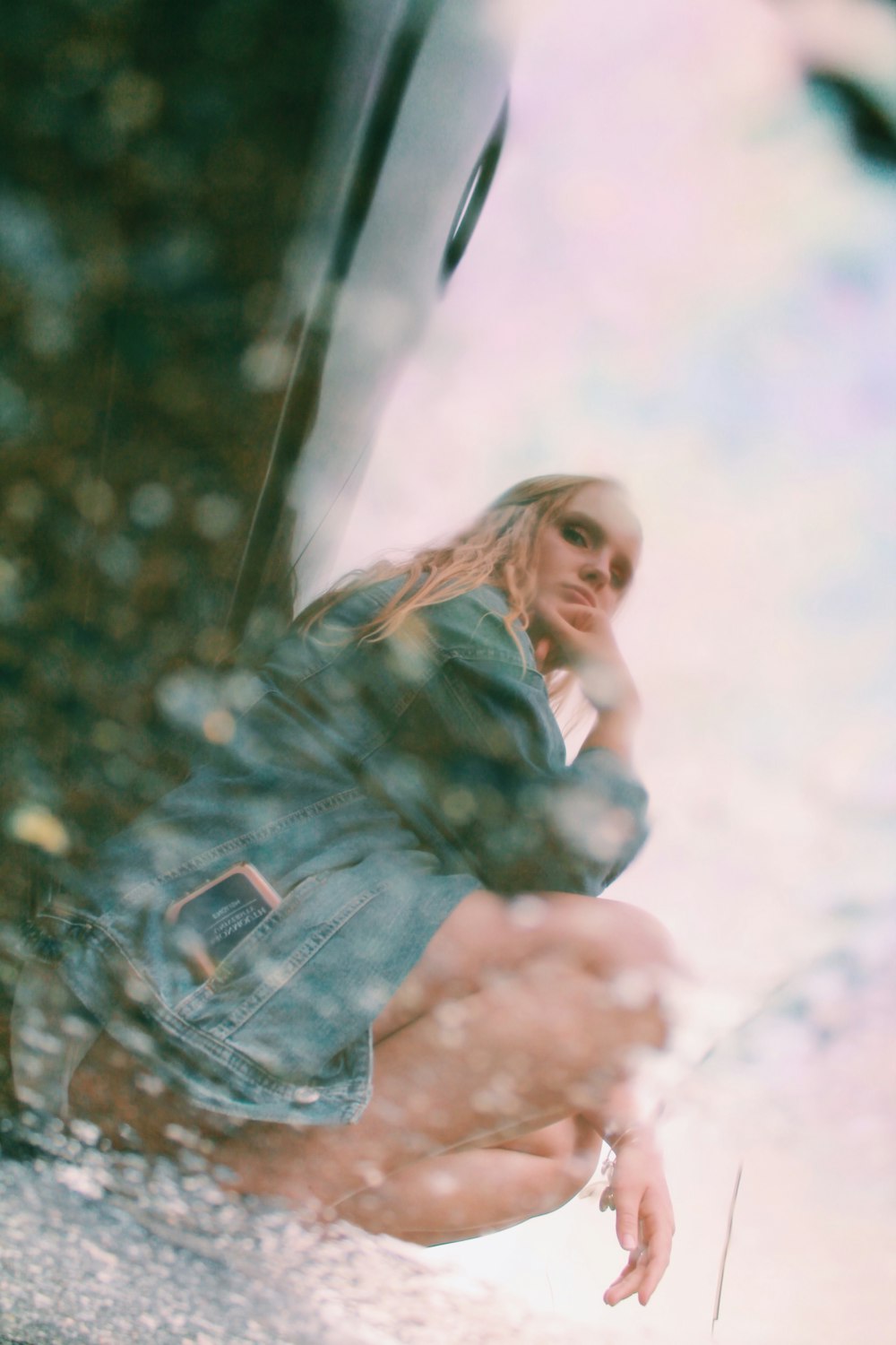 a woman leaning on the side of a car