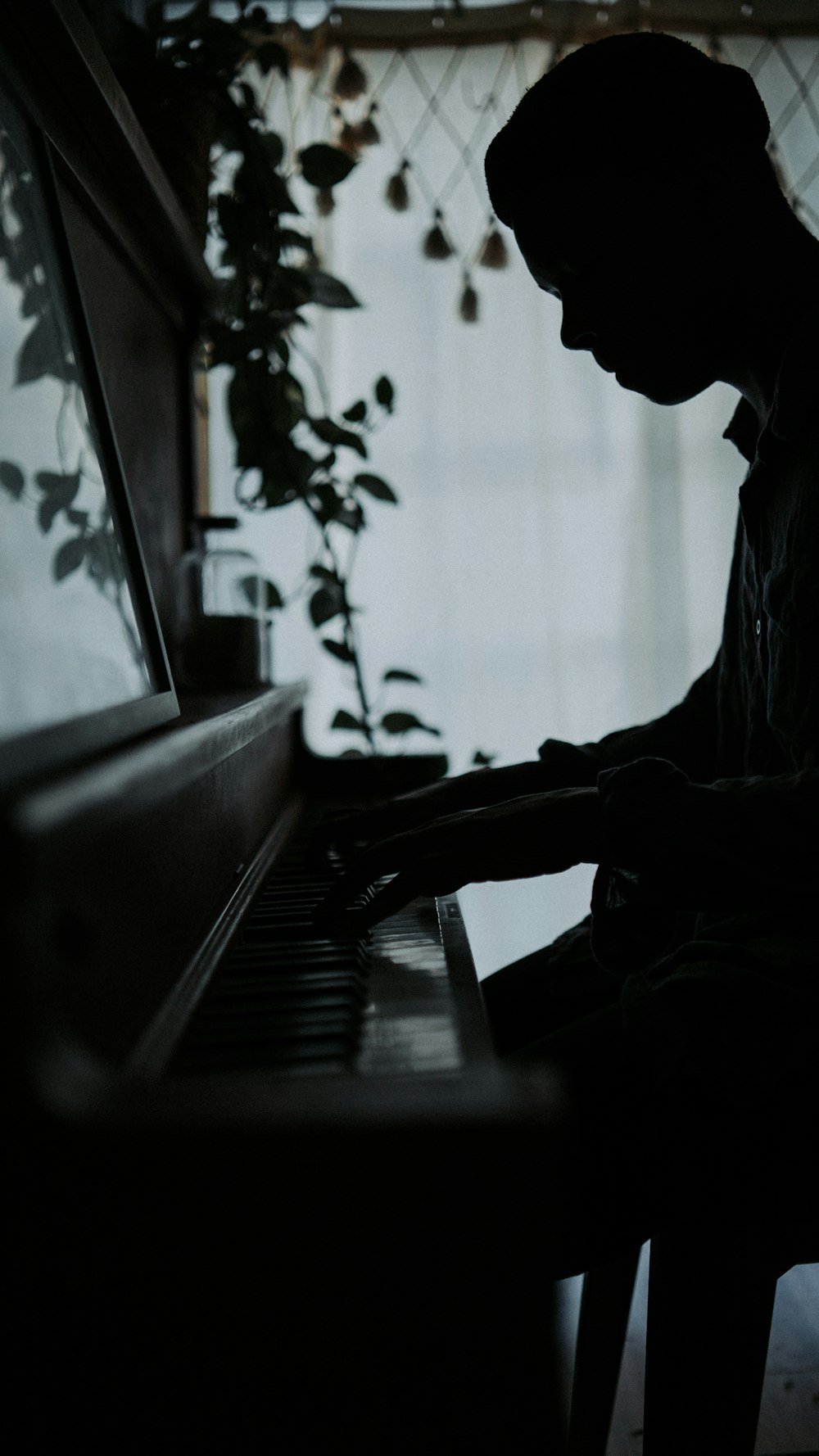 Un hombre tocando un piano en una habitación oscura
