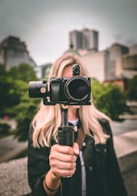 selective focus photography of woman holding camera gimbal
