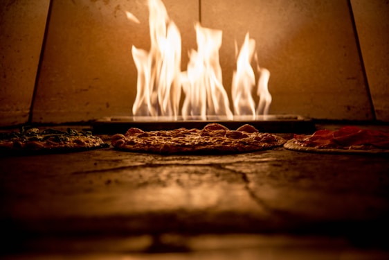 A warm, inviting pizza oven with a golden crust pizza being pulled out, steam rising gently.