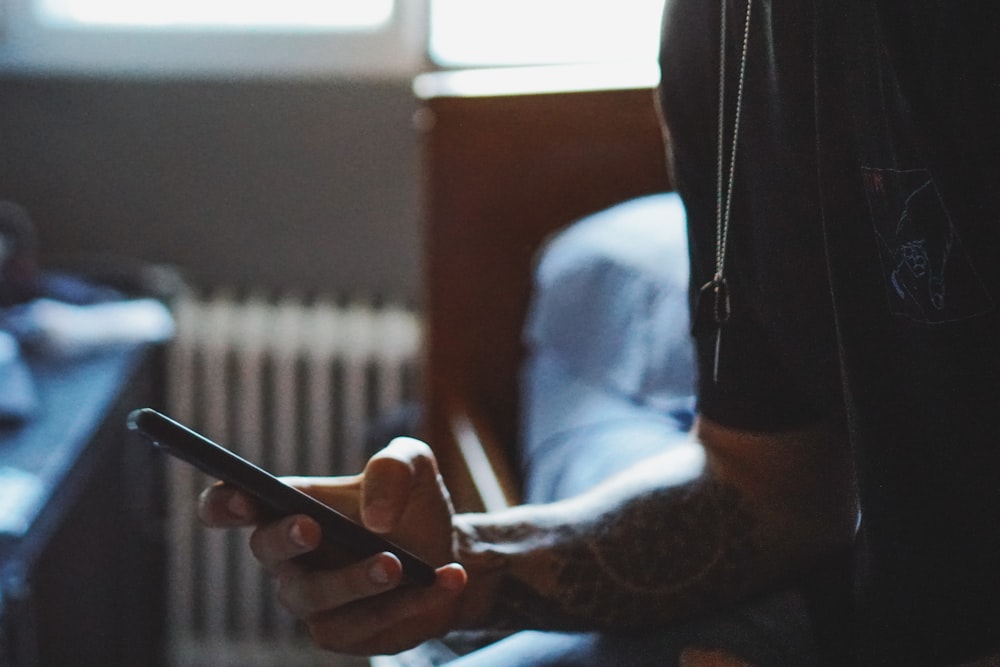 man holding black phone