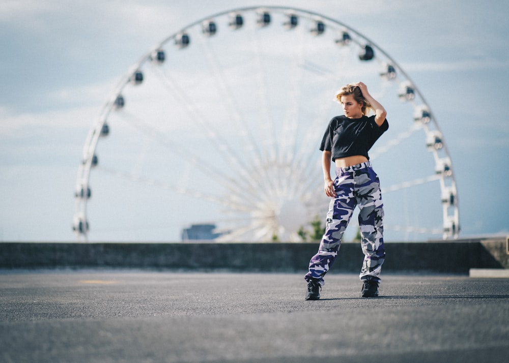 focus photo of woman with ferris wheel at background