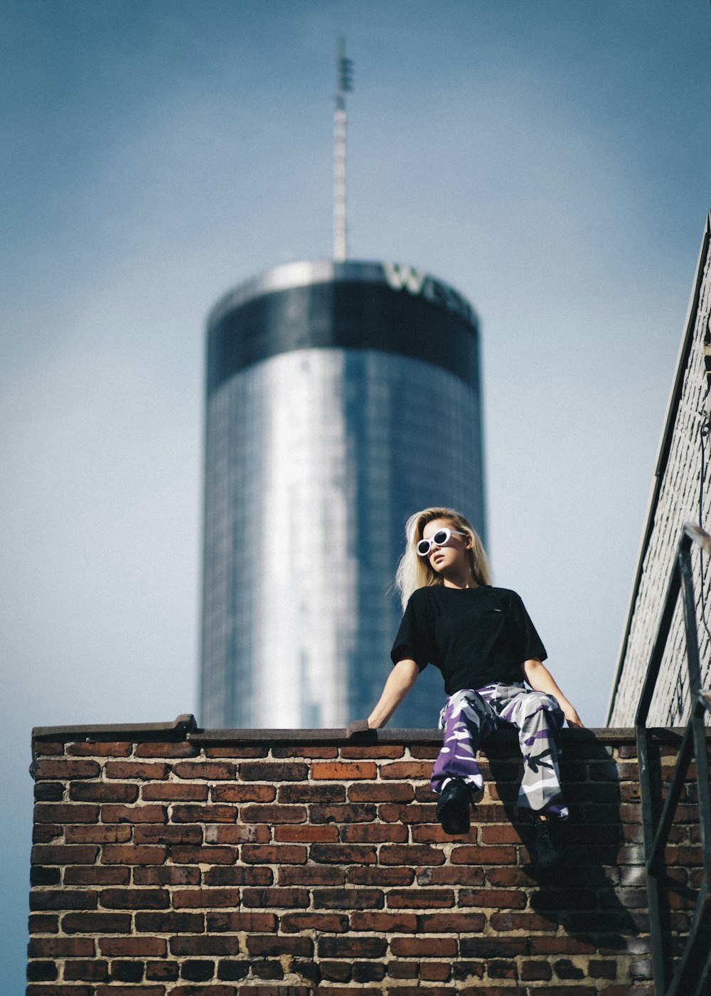 woman sitting on brick wall