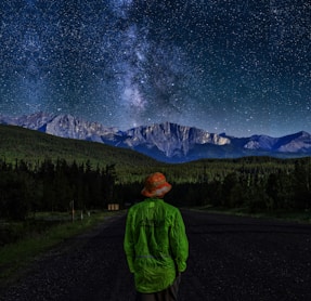person wearing green sweater standing near the house during nighttime illustration