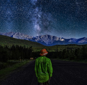 person wearing green sweater standing near the house during nighttime illustration