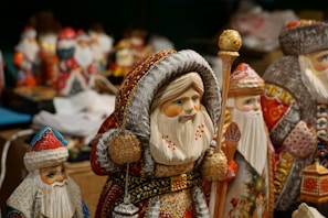 Artisan carefully painting delicate details on a wooden Christmas figurine.