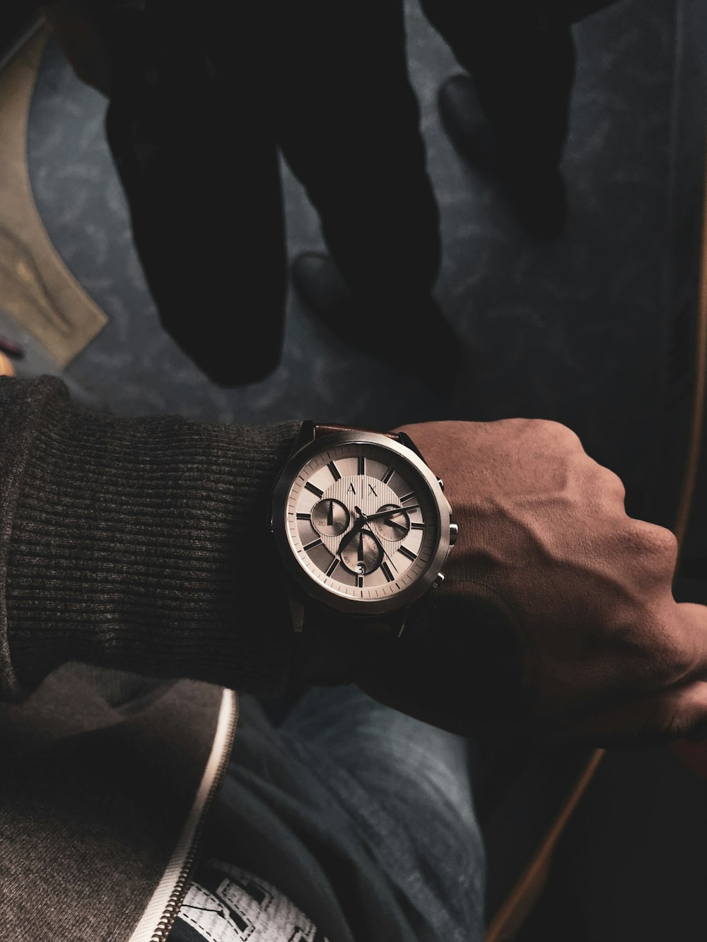 person wearing round gray chronograph watch