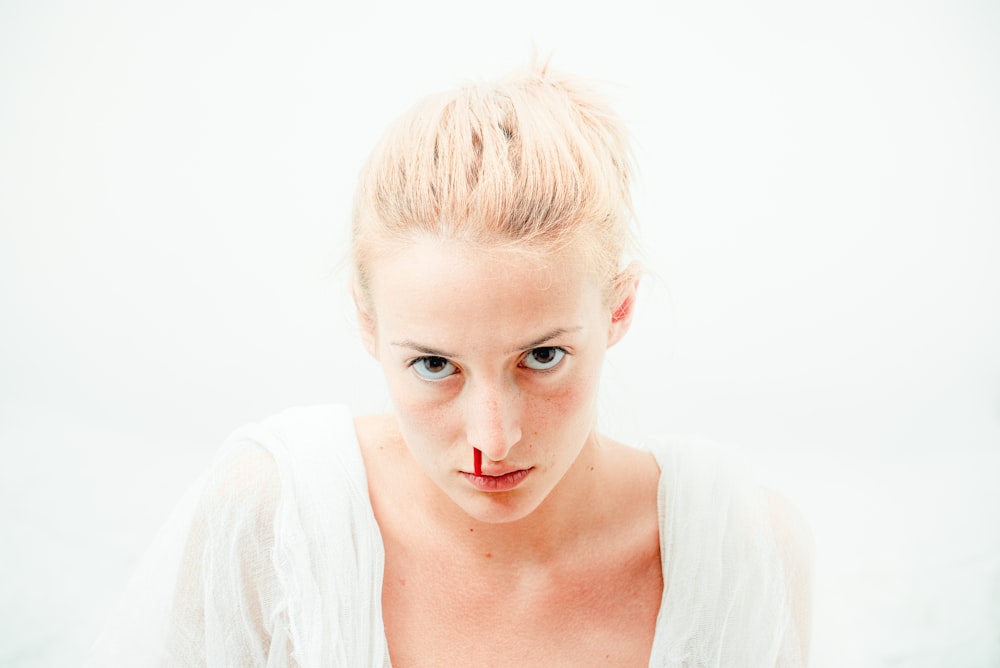 woman's bleeding nose with white background