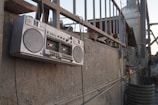 A vibrant 1980s street scene with a classic boombox and graffiti-covered brick wall.