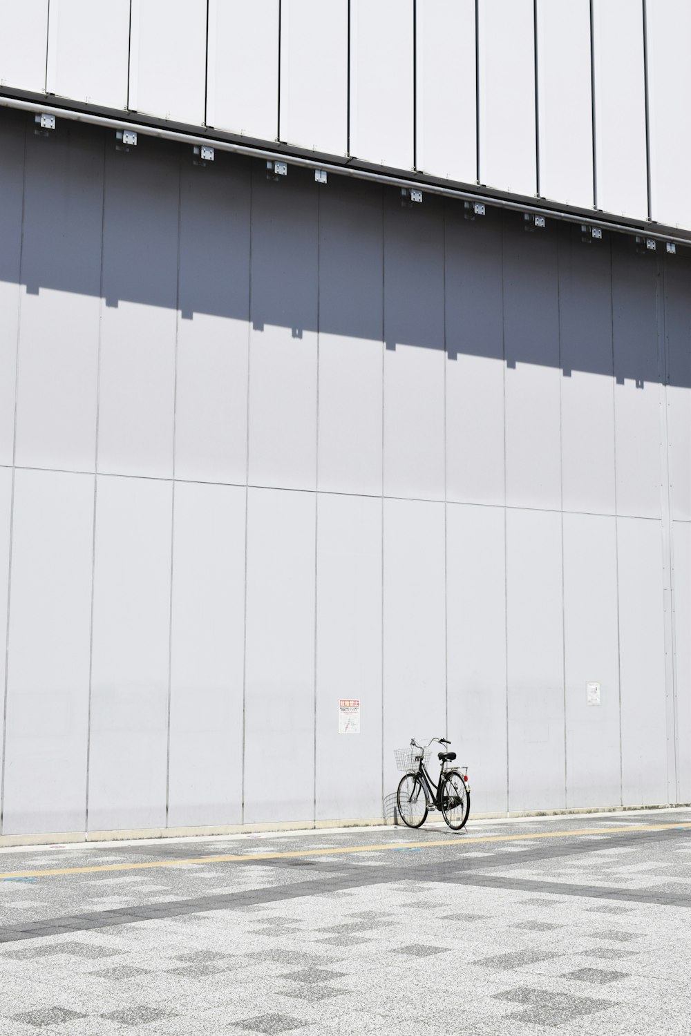 black commuter bike parking beside wall at daytime