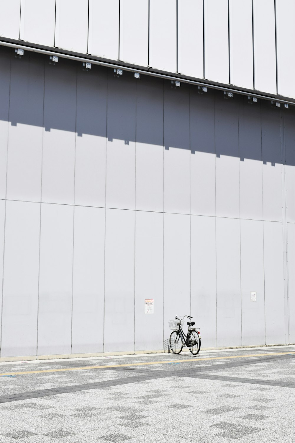 Estacionamiento de bicicletas de cercanías negro al lado de la pared durante el día