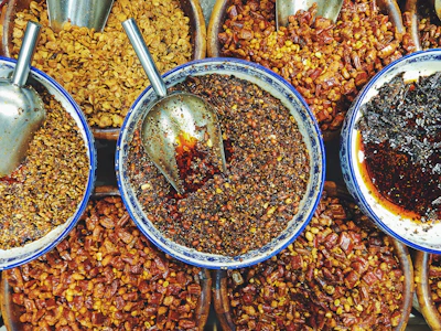 Colorful selection of spices and herbs displayed in small bowls.